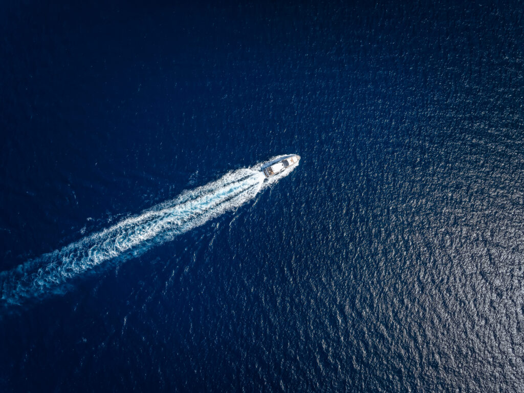 Aerial view of boat moving across the water and making waves