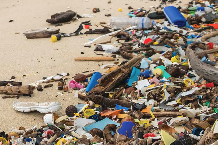 Plastics and trash of different types and colors litter a beach