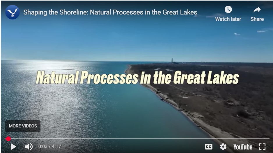 This image shows a head-on view of calm blue lake water as it meets the coastline. The coastline has steep beaches. There are many trees and two homes along the coast. The title, "Revetments and Seawall Structures in the Great Lakes" is displayed in text across the middle of the photo.