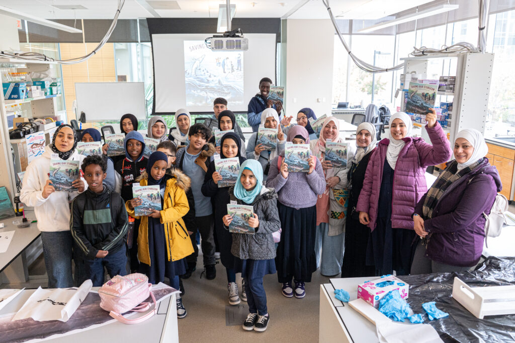 Group of students each posing with their own copy of the book, Saving Our Sturgeon.