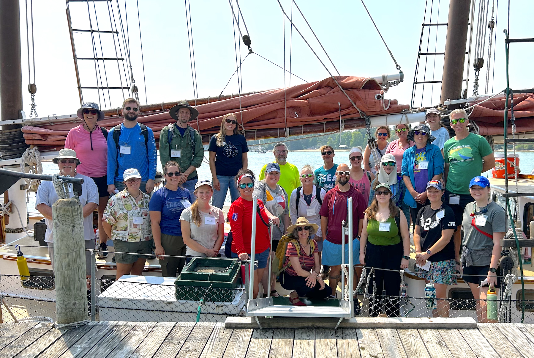 Educators stand in front of a schooner (tall ship) as part of the Great Lakes Field Course